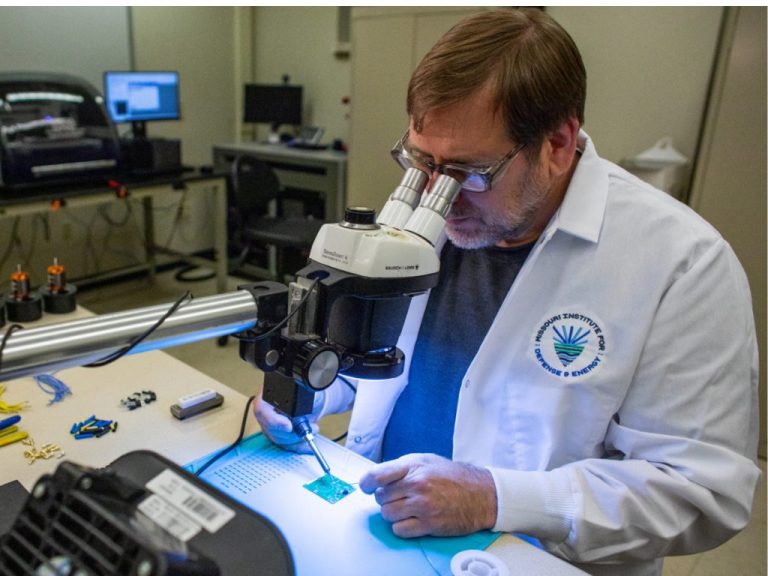 A UMKC researcher looks through a microscope.